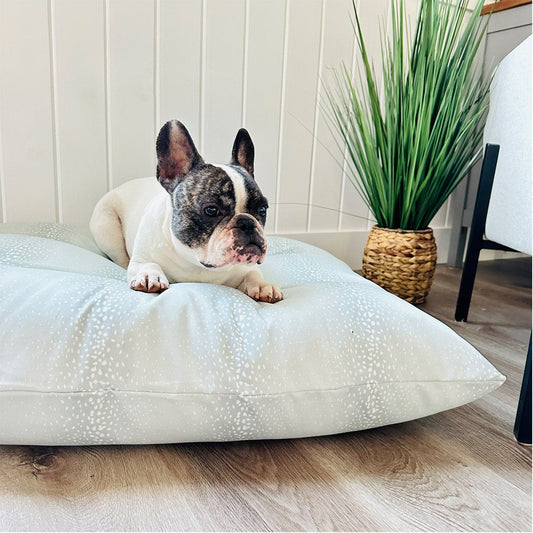 French Bulldog resting on a mineral antelope print dog bed with a natural, elegant pattern.